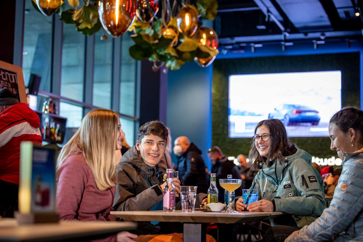 Vier Personen geniessen gemeinsam Getränke in der e-tron energy bar.