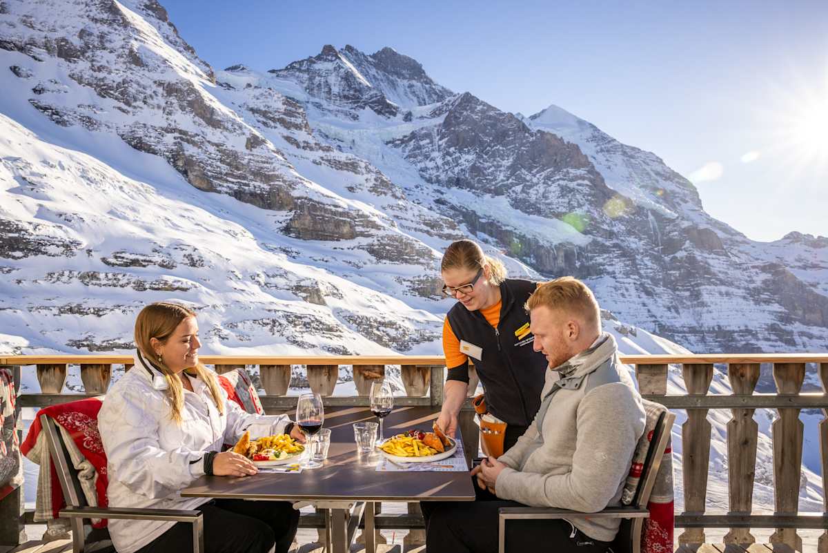 Gäste werden bedient auf der Terrasse des Restaurant Eigergletscher