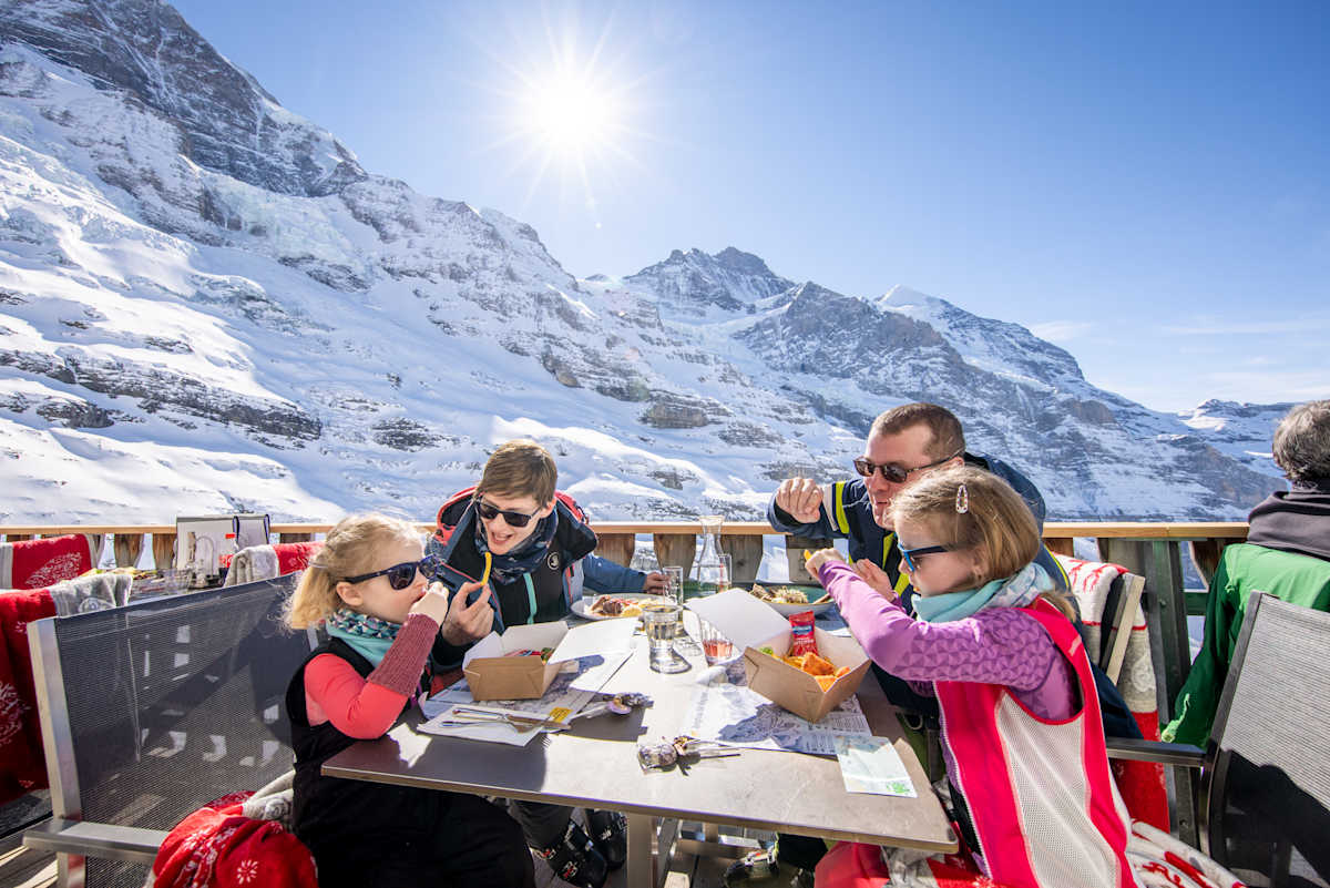 Familie isst auf der Terrasse des Restaurant Eigergletscher