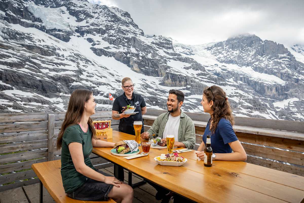 The Wall Bar terrasse avec trois personnes en train d’être servies